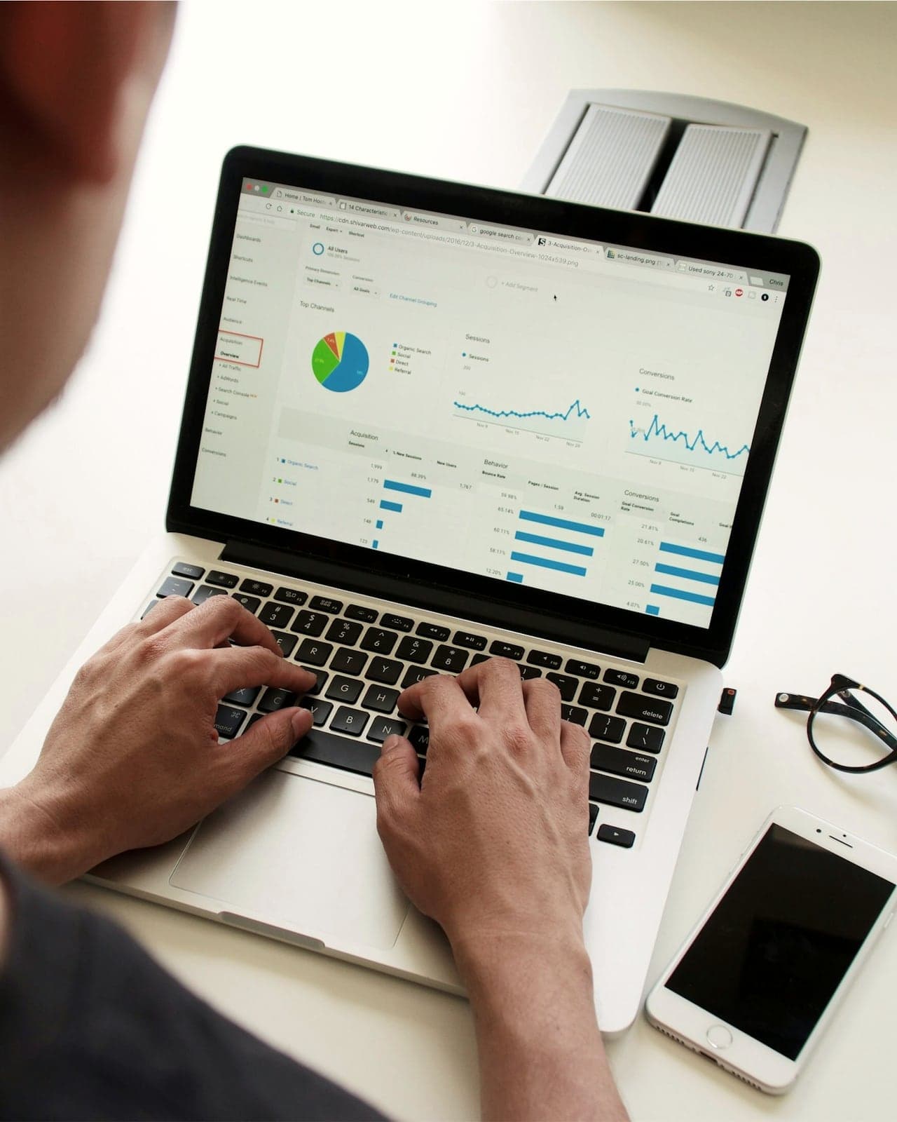 Persona trabajando en una computadora portátil que muestra un panel con gráficos de datos.